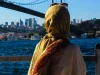 Ilustrasi perempuan berjilbab kuning dari belakang memandang Jembatan Bosphorus di Istanbul, Turki