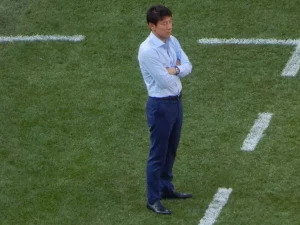 Shin Tae-yong berdiri bersedekap di pinggir lapangan saat Piala Dunia 2018