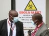 Petugas kesehatan bermasker berdiri di depan papan peringatan Ebola di Nairobi Hospital, Kenya