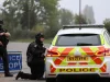 Polisi bersenjata berjaga di samping mobil patroli dekat pangkalan RAF Fairford