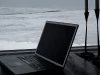 Laptop lama terbuka di meja dekat jendela