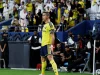 Cristiano Ronaldo berseragam kuning Al Nassr berdiri di lapangan dengan tribune penonton di belakangnya
