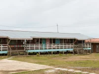 Bangunan kayu ruang kelas Sekolah Kebangsaan Rundum di Sabah, Malaysia, dengan halaman rumput