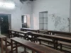 Ruang kelas kosong berbangku kayu di Baidya Para Girls High School, Kolkata, India