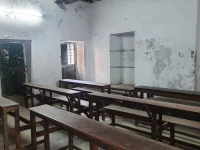 Ruang kelas kosong berbangku kayu di Baidya Para Girls High School, Kolkata, India