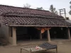 Rumah tradisional Rana Tharu berdinding tanah dan beratap genting di Tarai barat, Nepal