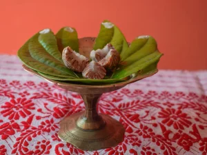 Potongan buah pinang di atas daun sirih dalam wadah kuningan khas Assam, India