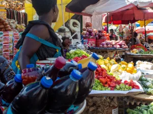 Ilustrasi lapak sayur dan buah warna-warni di Market Circle, Takoradi, Ghana
