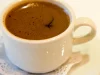 Ilustrasi: secangkir kopi Turki berbusa dalam cangkir putih di atas tatakan beralas kertas renda