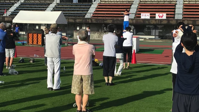 Warga lanjut usia mengikuti senam radio di lapangan stadion Kota Yamato, Jepang, pada 2019