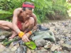 Seorang sikerei meramu obat dari tumbuhan hutan di tepi sungai Pulau Siberut, Mentawai