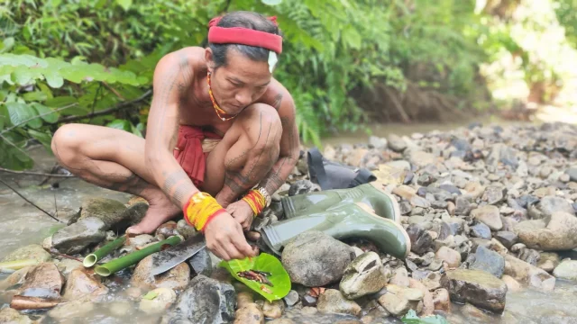 Seorang sikerei meramu obat dari tumbuhan hutan di tepi sungai Pulau Siberut, Mentawai