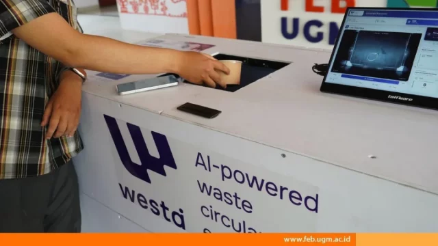 Pengguna memasukkan gelas bekas ke Smart Waste Bin buatan FEB UGM