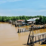 Ilustrasi rumah panggung, titian kayu, dan perahu nelayan di tepi Sungai Parit V, Kuala Tungkal, Jambi