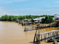 Ilustrasi rumah panggung, titian kayu, dan perahu nelayan di tepi Sungai Parit V, Kuala Tungkal, Jambi