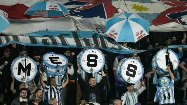 Suporter Argentina mengangkat drum bertuliskan huruf M-E-S-S-I di tribune Stadion Monumental, Buenos Aires