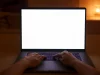 Ilustrasi dua tangan mengetik di laptop berlayar putih kosong di ruangan temaram