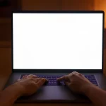 Ilustrasi dua tangan mengetik di laptop berlayar putih kosong di ruangan temaram