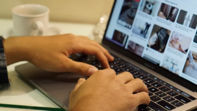 Ilustrasi dua tangan mengetik di papan ketik laptop di atas meja
