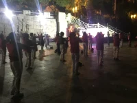 Ilustrasi warga menari bersama di lapangan terbuka pada malam hari di Fuding, Fujian, Tiongkok