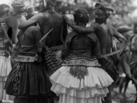 Penari berbaju adat saling merangkul dalam tari raego di Kulawi, Sulawesi Tengah, tahun 1918