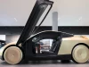 Mobil otonom Tesla Cybercab berwarna keemasan dengan pintu terbuka ke atas di ruang pamer