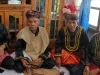 Empat tetua adat berbaju hitam bersulam emas duduk bersila saat Kenduri Sko