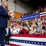 Donald Trump bertepuk tangan di depan pendukung dalam kampanye di Vandalia, Ohio
