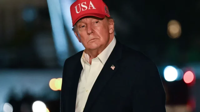 Presiden AS Donald Trump bertopi merah bertuliskan USA saat tiba di Gedung Putih