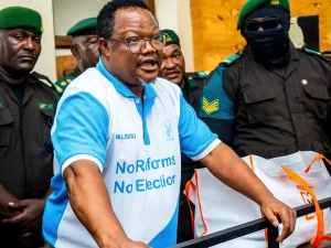 Tundu Lissu berkaus bertuliskan No Reforms No Election dikawal petugas di ruang sidang
