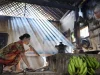 Perempuan Osing meniup api tungku dengan semprong bambu di Desa Kemiren, Banyuwangi