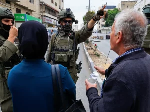 Warga Palestina berdebat dengan tentara Israel bersenjata di sebuah jalan di Hebron