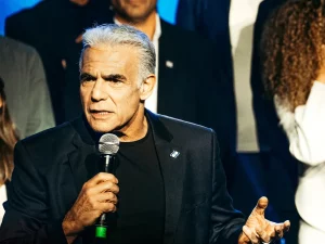 Pemimpin oposisi Israel Yair Lapid berbicara memegang mikrofon di Tel Aviv