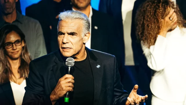 Pemimpin oposisi Israel Yair Lapid berbicara memegang mikrofon di Tel Aviv