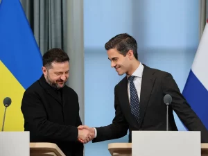Presiden Ukraina Zelenskyy berjabat tangan dengan PM Belanda Rob Jetten di depan bendera kedua negara