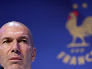 Zinedine Zidane dalam konferensi pers Timnas Prancis berlatar logo ayam jantan