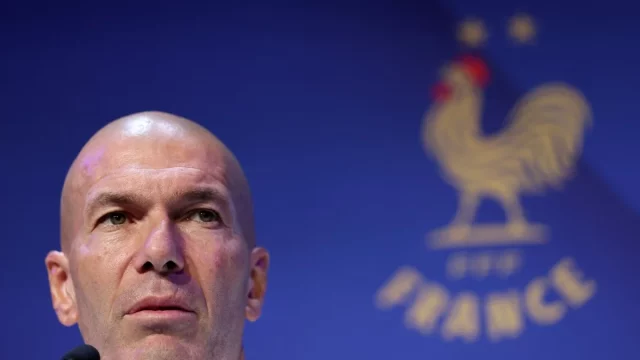 Zinedine Zidane dalam konferensi pers Timnas Prancis berlatar logo ayam jantan