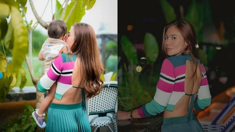 Kenakan baju rajut dengan punggung terbuka saat menggendeong seorang bayi, Wulan Guritno disebut sebagai hot mom.