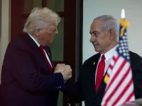 Donald Trump dan Benjamin Netanyahu berjabat tangan di Gedung Putih dengan bendera Amerika Serikat dan Israel di latar belakang